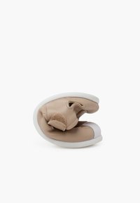 Scarpa in pelle beige con una consistenza morbida, caratterizzata da un'ampia accentatura bianca sulla punta e una chiusura a strappo per un facile accesso.