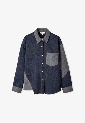 Chemise en denim froissée avec un corps bleu foncé, des accents gris et une poche poitrine. Fini avec des boutons métalliques et un col net.