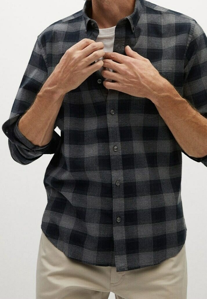Chemise à carreaux boutonnée en gris foncé et bleu marine, fabriquée en tissu doux. Dotée d'un col et de manches longues retroussées aux poignets.