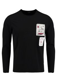 Schwarzes Langarm-T-Shirt aus Baumwolle mit aufgedruckten Patches in Weiß und Bordeaux mit verschiedenen Designs im Brustbereich.