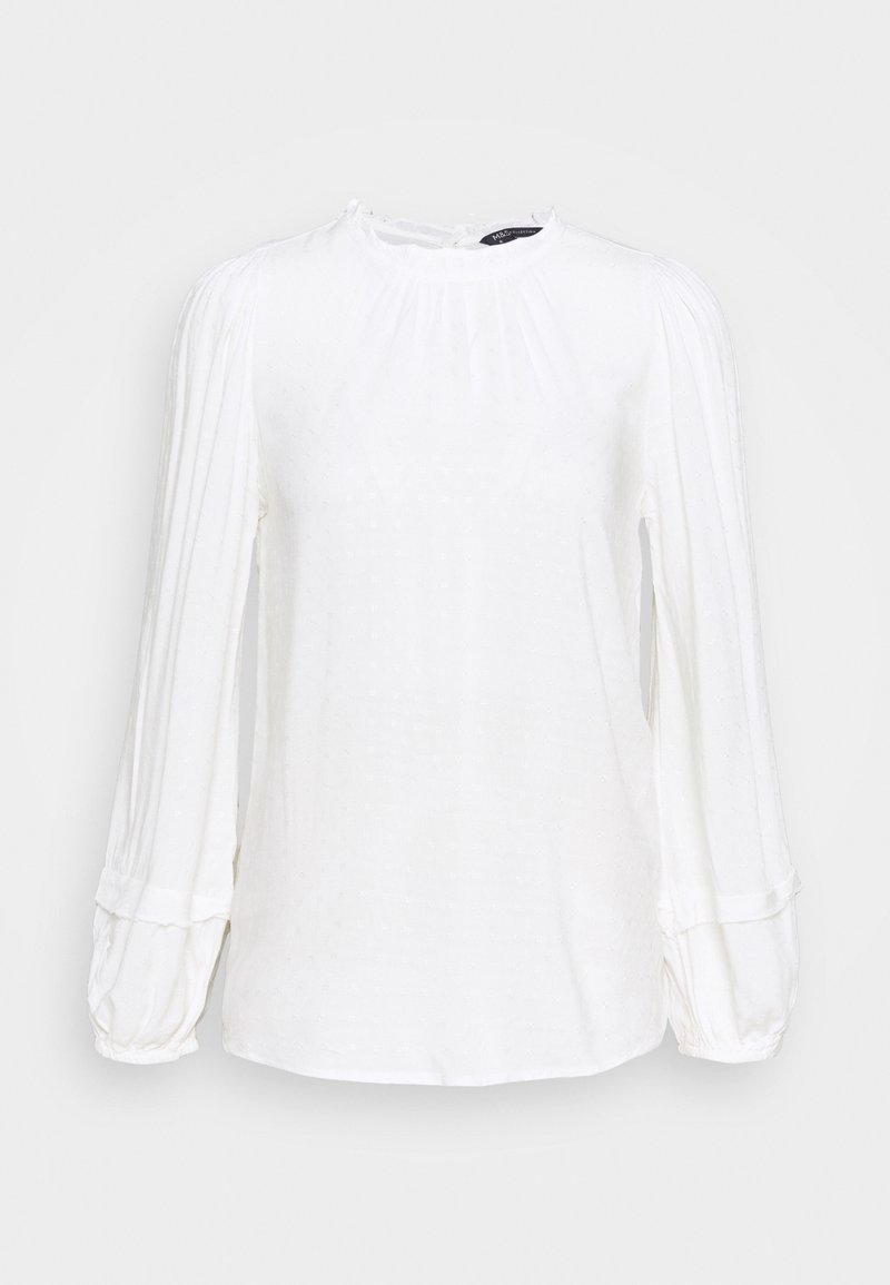 Blouse blanche à manches longues avec manches ballon plissées et col rond, présentée sur un fond uni gris clair.
