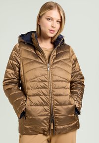 Brun dunjakke med quiltet design, lynlås foran og hætte foret med blå stof. Glat tekstur med sidelommer og tætsiddende ærmer.