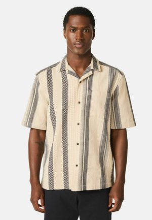 Kurzärmeliges Hemd in Creme mit schwarz gestreiften Mustern; verfügt über eine durchgehende Knopfleiste, strukturierte Stoffe und eine Brusttasche.