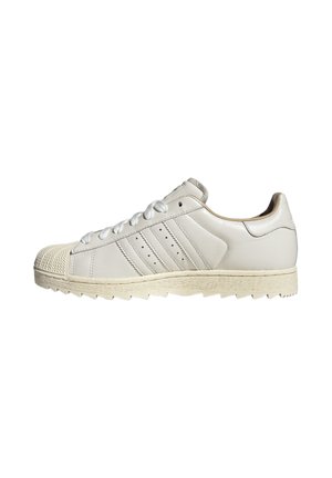 Sneaker in pelle bianca a taglio basso con puntale in gomma strutturata, chiusura frontale con lacci e suola in gomma scanalata, vista laterale su sfondo bianco.