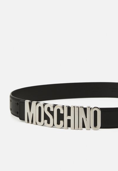 Melna ādas josta ar izteiktu sudraba "MOSCHINO" logotipa sprādzi. Gluda tekstūra ar caurumiem gar garumu, lai pielāgotu izmēru.