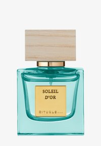 Bouteille de parfum avec une base en verre turquoise transparent, une étiquette dorée et un bouchon en bois clair. Forme élégante avec des bords lisses.