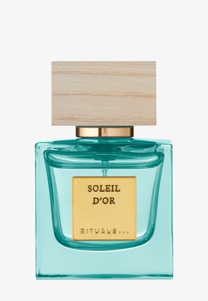 Bouteille de parfum avec une base en verre turquoise transparent, une étiquette dorée et un bouchon en bois clair. Forme élégante avec des bords lisses.
