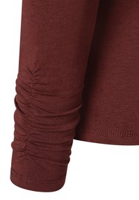 Langarm-Top aus burgunderrotem Stoff, mit einer gerafften Textur an den Bündchen und einem glatten Körper, mit einem sauber genähten Saum.