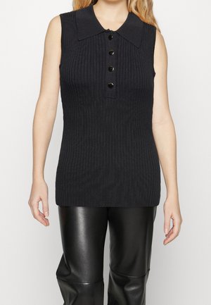 Czarny prążkowany bezrękawnik typu polo z czterema czarnymi guzikami, noszony z czarnymi skórzanymi spodniami, widoczny od ramion do połowy uda.