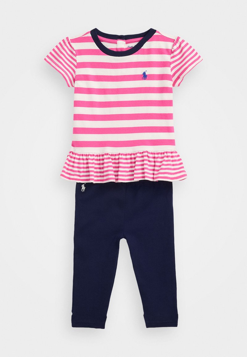 Top peplum a rayas rosa y blanca con ribete azul marino y logo, combinado con leggings azul marino lisos. Tejido de algodón, mangas cortas, dobladillo recogido.