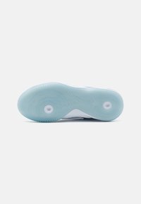 Suola di scarpa da ginnastica in gomma azzurro chiaro con un motivo testurizzato, caratterizzata da accenti circolari e un bordo bianco liscio.
