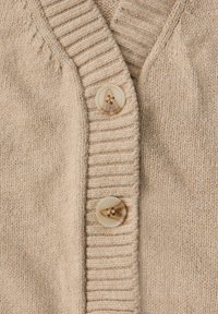 Beige gebreide cardigan met een geribbelde kraag en drie grote, doorschijnende knopen aan de voorkant. Zachte textuur en fijne stikdetails.