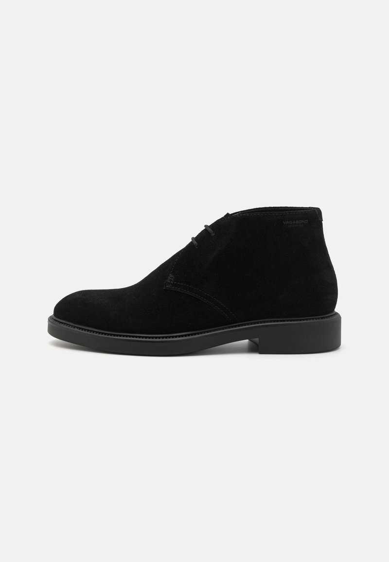 Bottine en daim noire à lacets, talon bas et bout arrondi, vue de l'extérieur sur fond blanc.