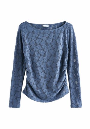 Top blu a maniche lunghe in tessuto di pizzo con motivo floreale. Presenta una scollatura tonda e un dettaglio arricciato ai lati.