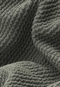 Textured gray fabric with a ribbed pattern, featuring subtle sparkle, creating a soft and uneven surface.