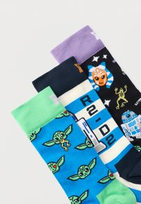 Τρία ζευγάρια πολύχρωμες κάλτσες με θέμα το Star Wars, που απεικονίζουν πρόσωπα του Baby Yoda, ένα μπλε-λευκό ριγέ σχέδιο ρομπότ και διάφορα πρόσωπα χαρακτήρων σε μαύρο φόντο.