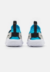 Sportovní boty se šedým a modrým textilním svrškem, prodyšnou síťovinou uvnitř, měkkou bílou podešví a černými poutky na patě pro snadné obouvání.