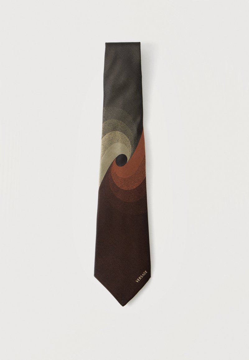 Καφέ γραβάτα με μοτίβο στροβιλισμού σε αποχρώσεις μπεζ, σκουριάς και σκούρου καφέ, με μικρό χρυσό λογότυπο "Versace" κοντά στην άκρη.