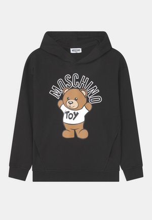 Sort hættetrøje med en tegneserie-bamse, der har en hvid skjorte på med teksten "Toy" og ordet "MOSCHINO" over bamsen.