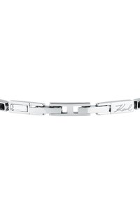 Armband i silverfärgad metall med rektangulära länkar, släta ytor och en diskret ingraverad signaturdetalj. Inkluderar svarta och klara accenter.