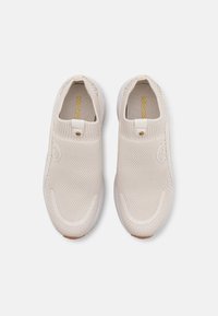 Béžové slip-on boty s pletenou síťovanou vrchní částí, elastickým lemem, jemným logem a texturovanou gumovou podrážkou. Lehký a flexibilní design.