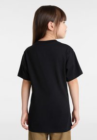 Schwarzes Baumwoll-T-Shirt mit kurzen Ärmeln, einem Rundhalsausschnitt und einem lässigen Schnitt, von hinten gezeigt mit einer glatten Textur.