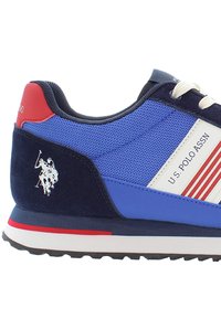 Blue sneaker with mesh and suede materials, featuring red accents, white side stripes, and a logo of a polo player on the side.