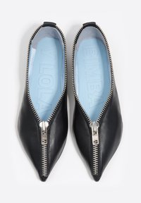 Czarne mokasyny ze skóry z zakończeniem w szpic, z ozdobnym srebrnym zamkiem wzdłuż górnej krawędzi oraz jasnobłękitną wkładką.