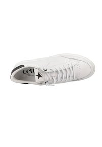 Zapatilla de piel blanca con cordones planos, detalles perforados, acento negro en el talón y logo en la lengüeta. Punta redondeada y textura suave.