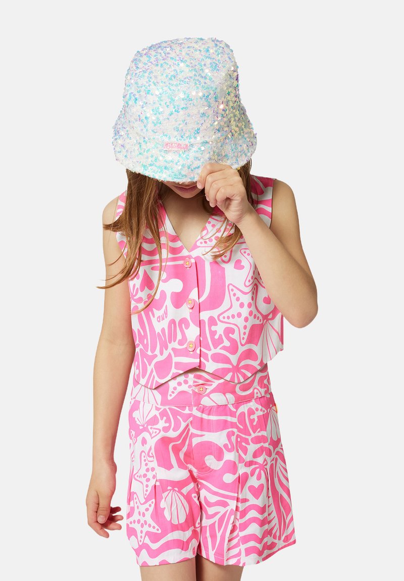 Haut sans manches rose et short à motifs blancs audacieux ; associé à un chapeau seau pastel scintillant. Le matériau semble léger.