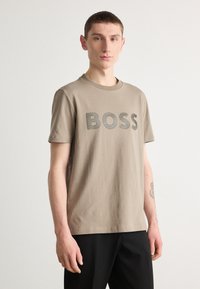 Kaklo medvilnės marškinėliai su ryškiu pilku "BOSS" logotipu priekyje, trumpomis rankovėmis ir klasikiniu apvaliu iškirpimu.