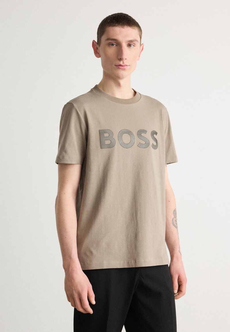 Kaklo medvilnės marškinėliai su ryškiu pilku "BOSS" logotipu priekyje, trumpomis rankovėmis ir klasikiniu apvaliu iškirpimu.
