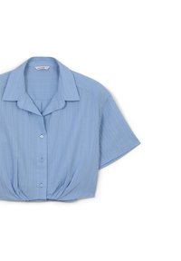 Camicia corta a maniche con colletto di colore azzurro chiaro, caratterizzata da righe verticali e una vita arricciata. Chiusura frontale con bottoni tondi piccoli.