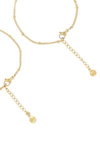 Pulsera de cadena de oro con un diseño delicado que incluye cuentas y un cierre de langosta. Longitud ajustable con un pequeño detalle en forma de colgante.