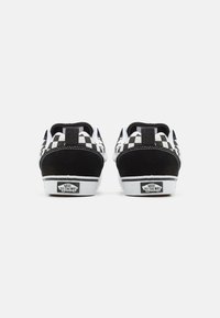 Sneaker in un motivo a scacchi bianco e nero con accenti in pelle scamosciata, lacci piatti e suole in gomma bianca. Presenta il logo Vans sul tallone.