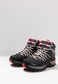 High-top hiking boots in black with pink accents. Features robust material, textured surface, and thick rubber outsole for traction.