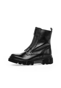Black leather ankle boot with a side zipper, chunky rubber sole, rounded toe, and subtle stitching details.