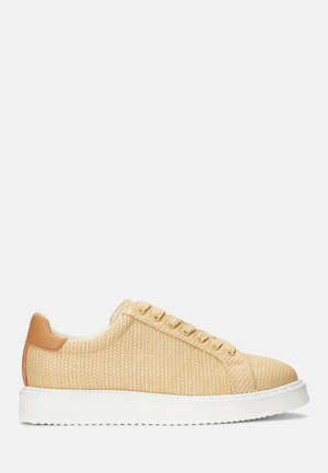 Beżowy, tkany niski sneaker z zapięciem na sznurówki, białą podeszwą oraz jasnobrązową skórzaną zakładką na pięcie, pokazany z profilu.