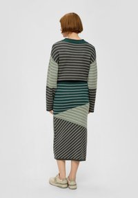 Strickkleid in Dunkelgrün, Hellgrün und Grau mit diagonalen Streifen. Kurze, cropped Ärmel und figurbetonte Silhouette.