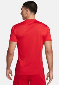 Rotes Sport-T-Shirt mit kurzen Ärmeln und rundem Halsausschnitt, aus einem glatten, atmungsaktiven Stoff mit feiner Textur.