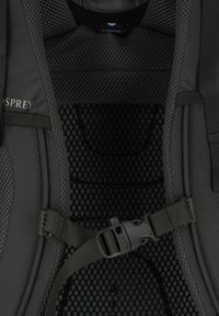 Zwarte hydratatietas interieur met gaasventilatie, verstelbare bandjes en plastic gesp. Textuurstof met een stippenpatroon.