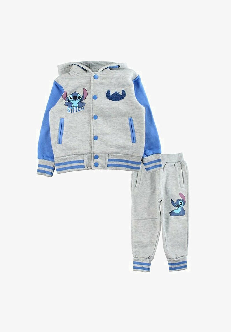 Veste à capuche grise avec manches bleues, ornée de motifs brodés de Stitch. Pantalon de jogging gris assorti, les deux en tissu doux.