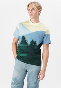 Tričko s krátkým rukávem s gradientním designem v zelených, modrých a žlutých odstínech, ztvárňující krajinu se stromy a horami.