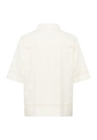 Hátsó nézet rövid ujjú fehér blúzról, amelyen lyukacsos csipke díszítés és finom virágmotívumos hímzés található könnyű anyagon.