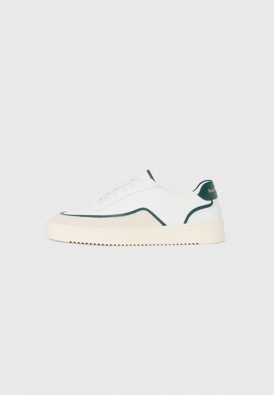Sneaker alb cu vârf jos, cu detalii verzi, detalii din suede bej și o talpă de culoare crem cu bază striată.