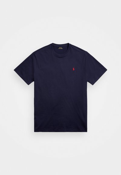 Mørk marineblå T-skjorte laget av bomull, med rund hals og kort erm. En liten rød logo er brodert på venstre bryst.