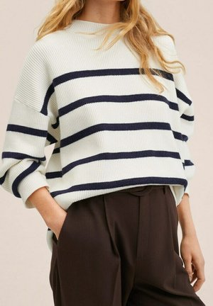 Suéter blanco acanalado con rayas horizontales azul marino, de corte relajado, mangas anchas y escote redondo, combinado con pantalones marrones.