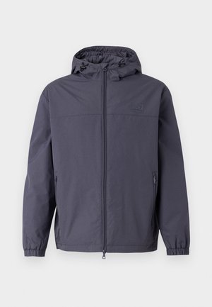 Vedenkestävä hupparitakki tummanharmaana, jossa on täysi etuvetoketju, joustavat hihansuut ja kaksi sivutaskua. Liukas, matta pinta.