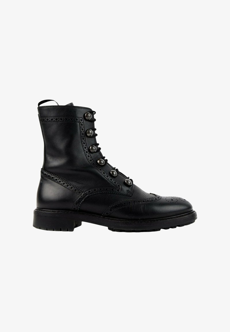 Bottine noire en cuir avec détails brogue, six œillets métalliques pour les lacets et une épaisse semelle en caoutchouc, vue de profil.