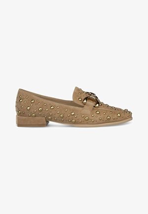 Beige Wildleder Slipper mit goldfarbenen Nieten und Schnallen-Details. Flacher Absatz, runde Zehen und strukturierte Oberfläche mit dekorativen Akzenten.